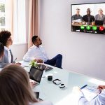 Group Of Skillful Businesspeople Video Conferencing In Boardroom